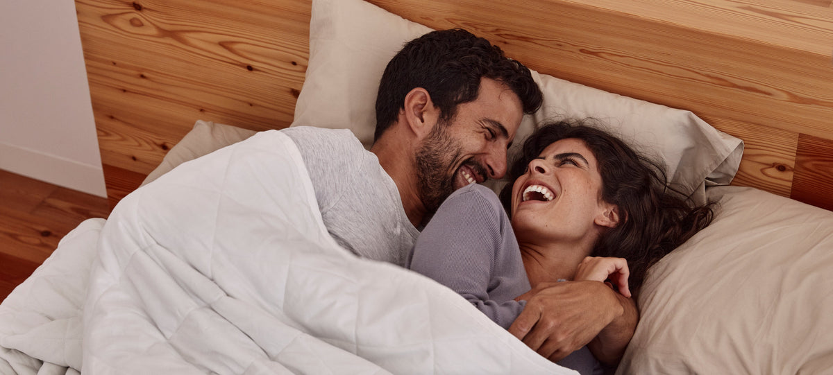 Casal a acordar bem-disposto debaixo do blanky